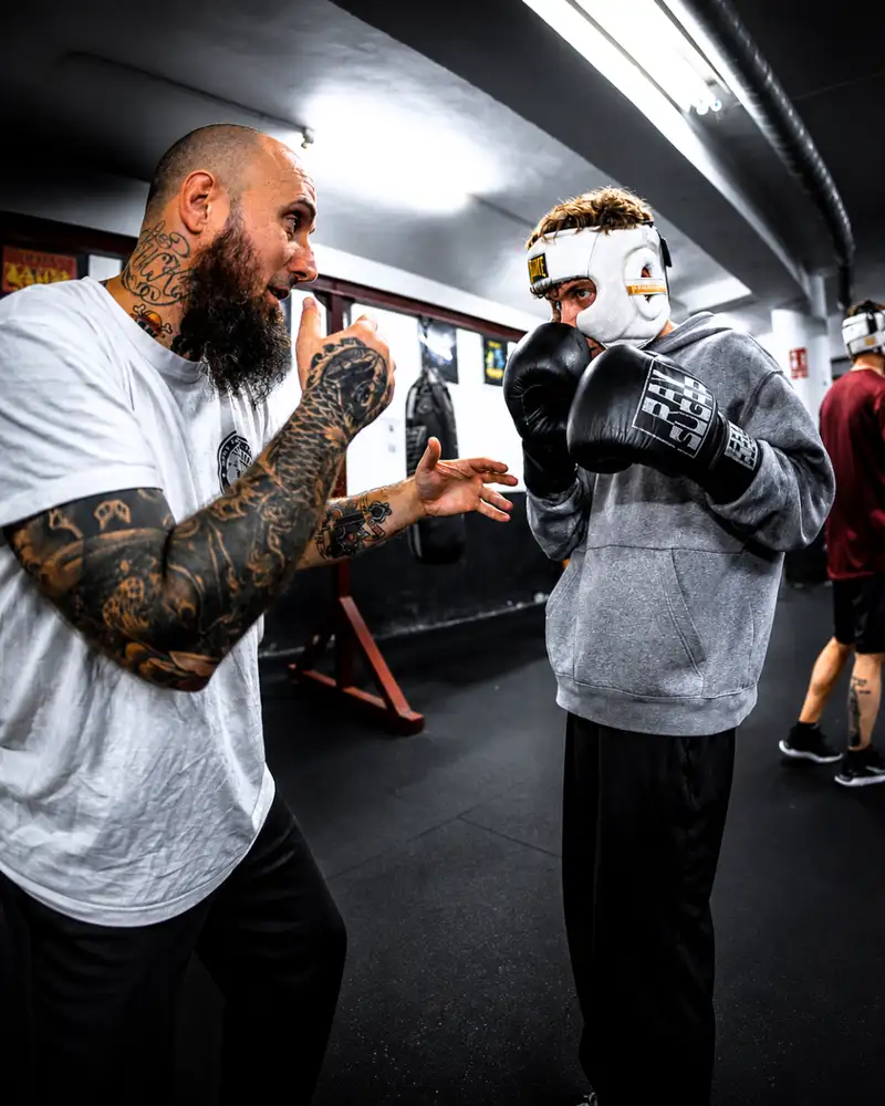 Entrenador corrigiendo técnica de boxeo uno a uno en Ilion Boxing Club Barcelona
